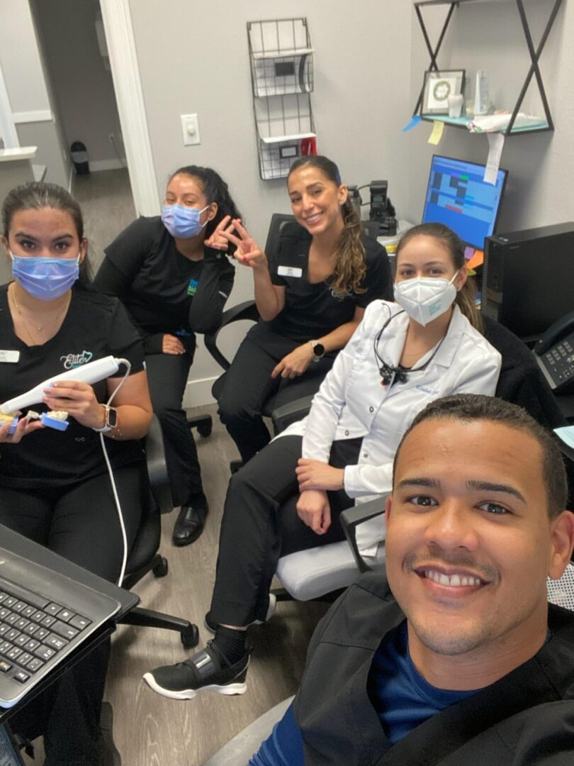 A group of people sitting in front of a computer.