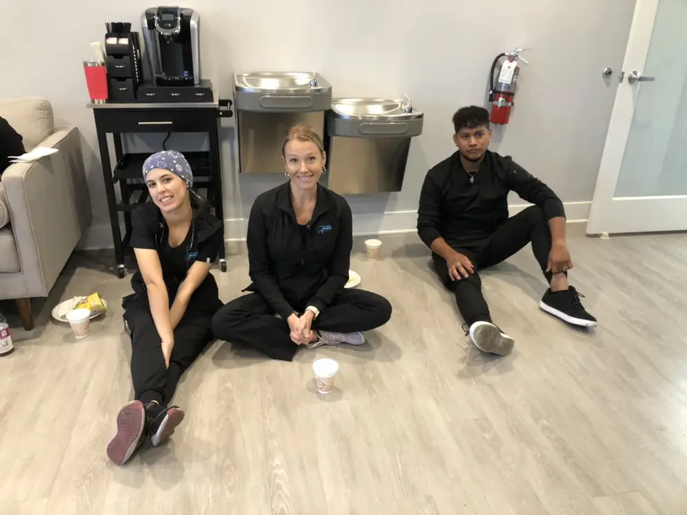 Three people sitting on the floor in a room