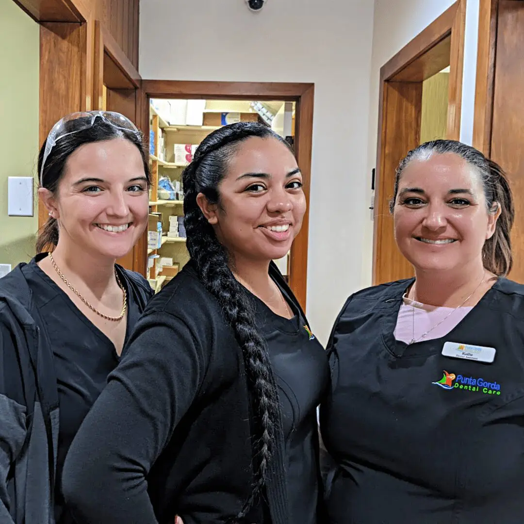 Three women in black shirts smiling for a picture.