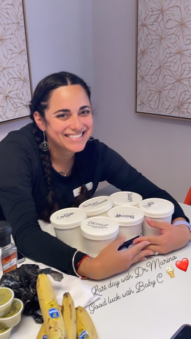 A woman sitting at a table with many cups of coffee.