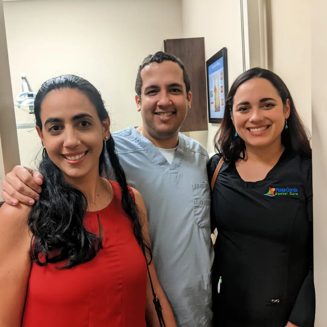 Three people posing for a picture in front of the camera.