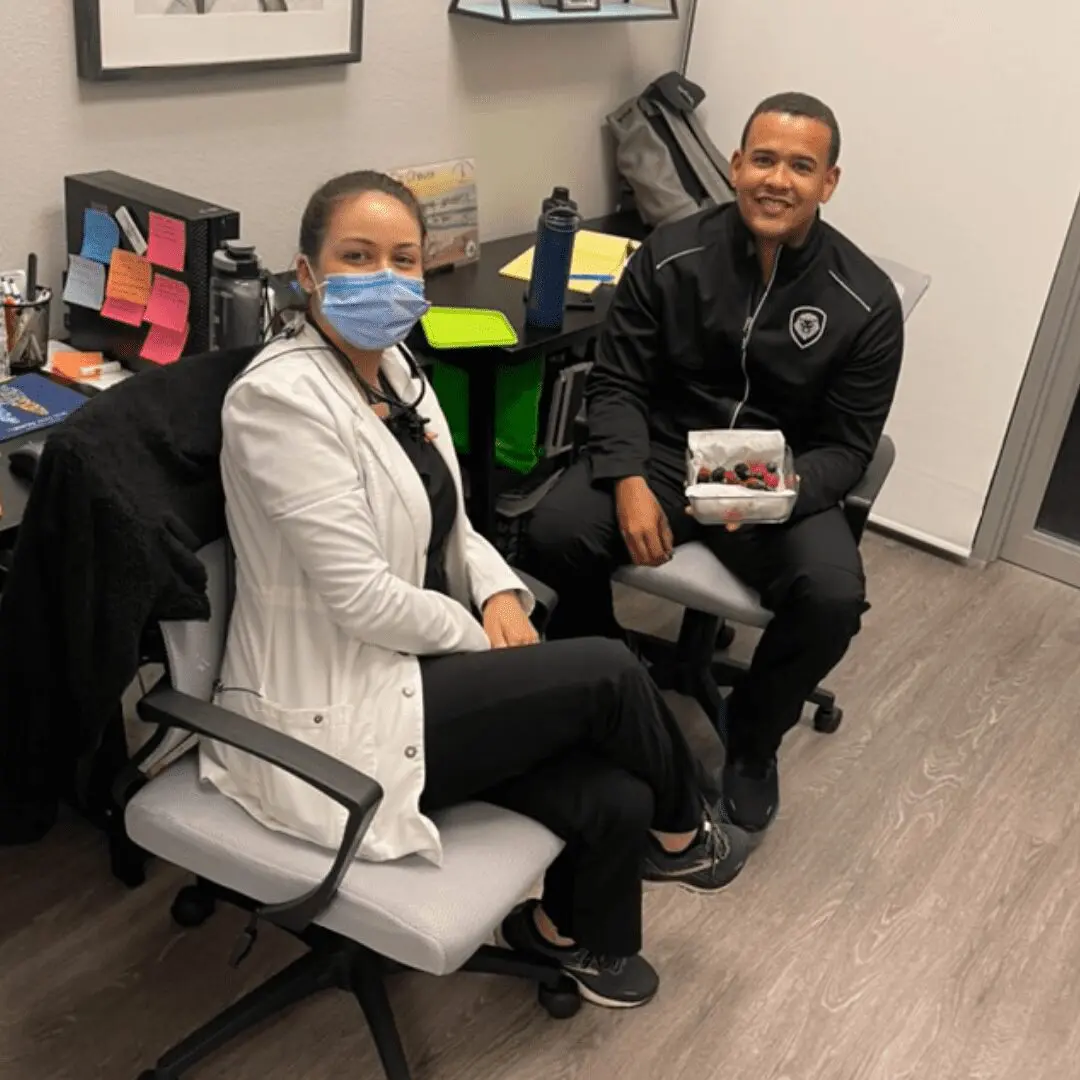 Two people sitting in a room with some bags