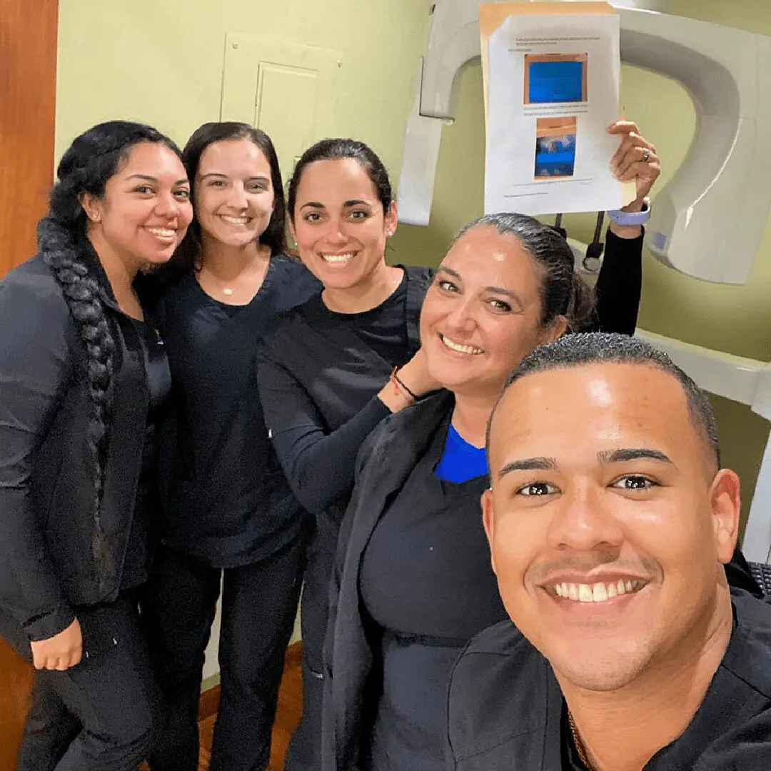 A group of people standing in front of an x-ray machine.