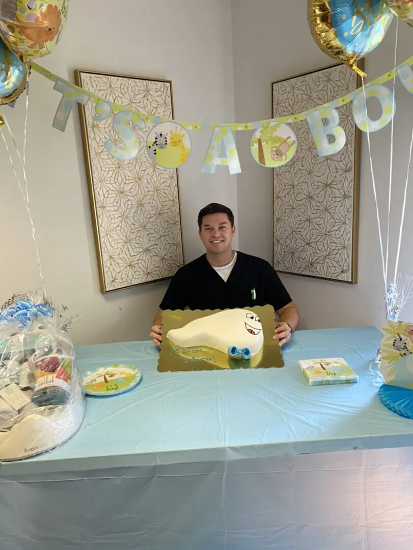 A man sitting at the table with a cake.