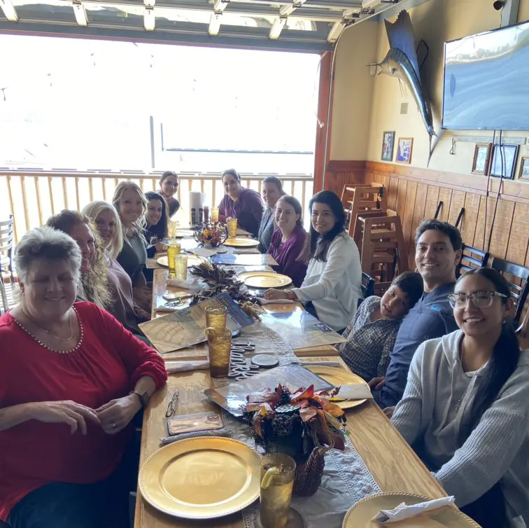 A group of people sitting at a table with plates.