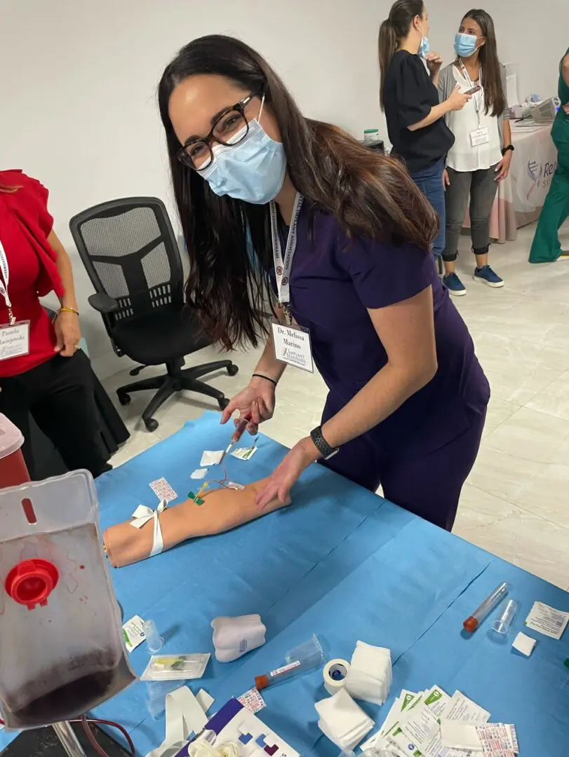 A woman in blue shirt cutting paper on table.