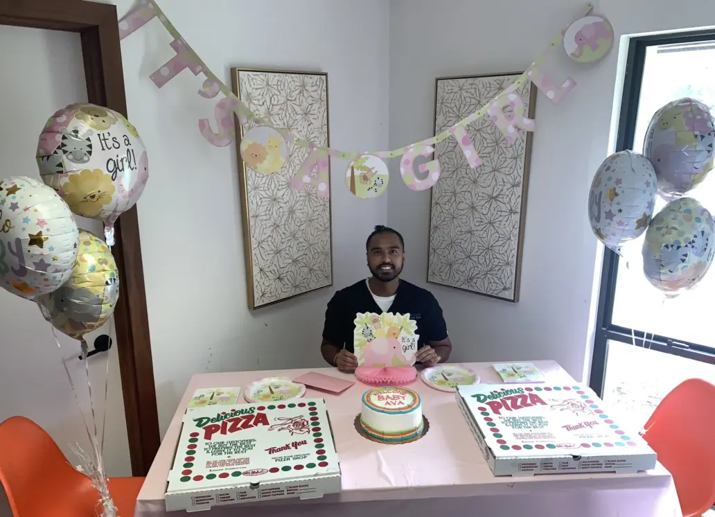 A man sitting at the table with two cakes.