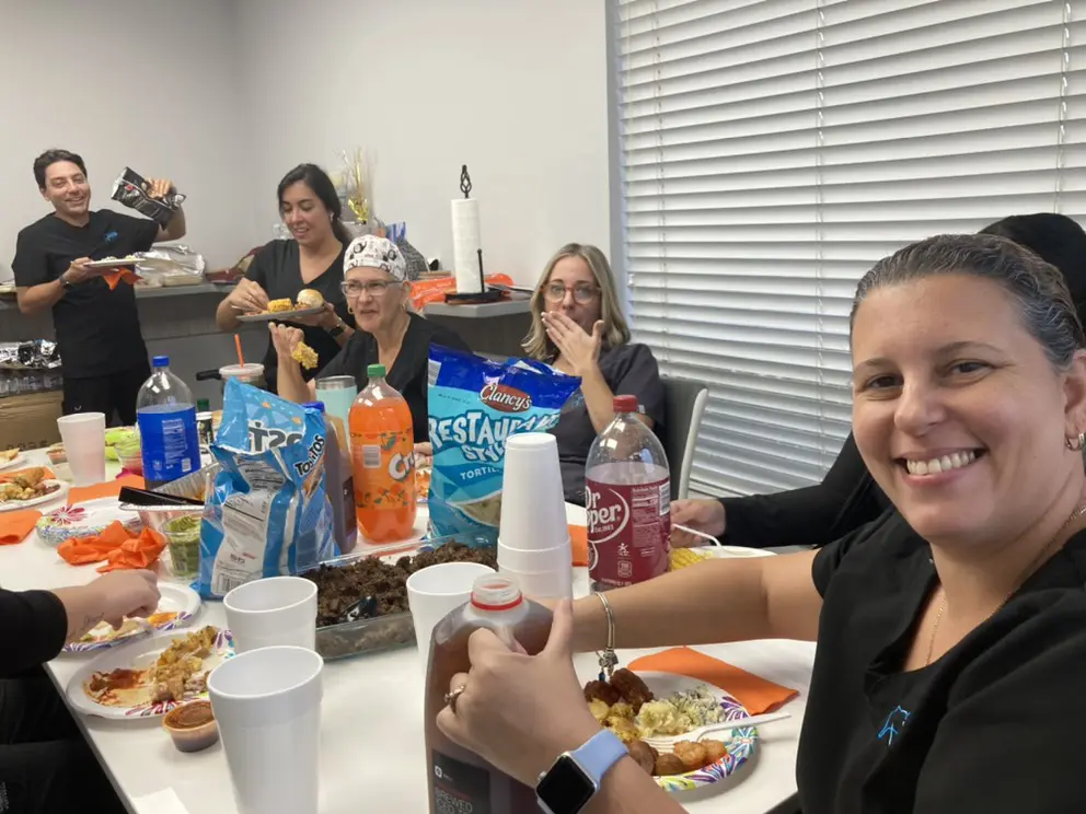 A group of people sitting at a table with food.