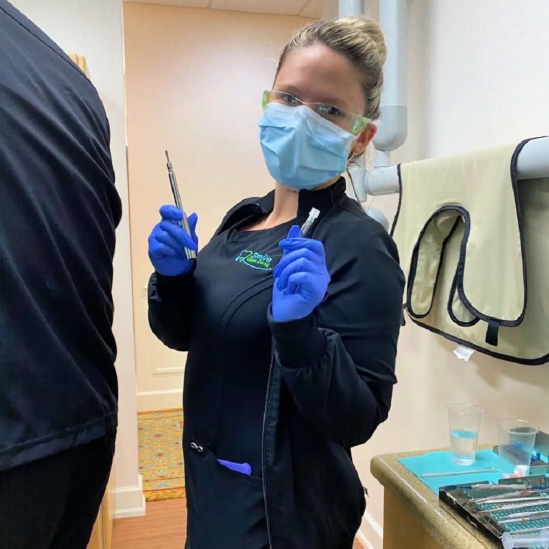 A woman in black jacket holding a tooth brush.