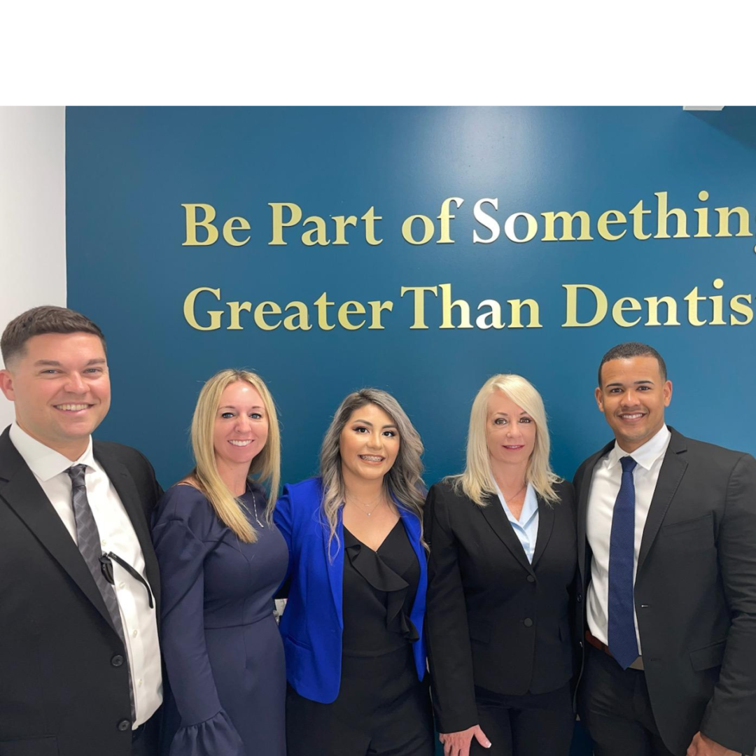 A group of people standing in front of a sign.