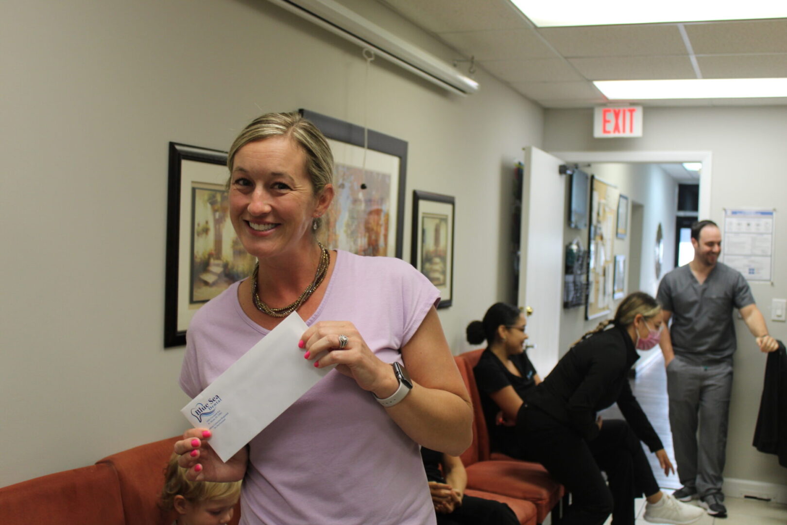 A woman holding an envelope in her hand.