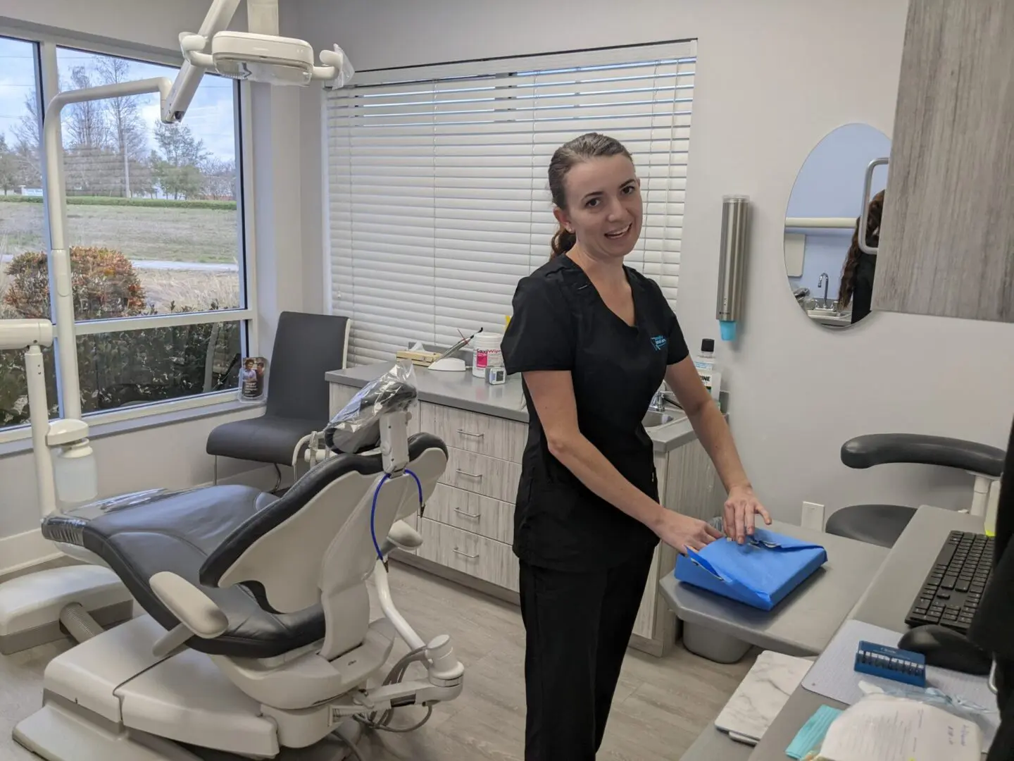 A woman standing in front of some dental equipment.