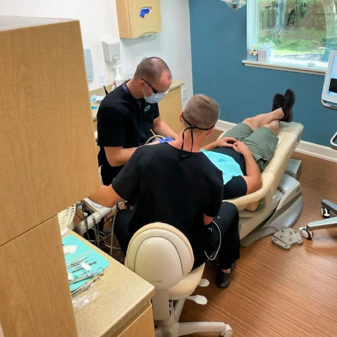 A man is sitting in the dentist chair