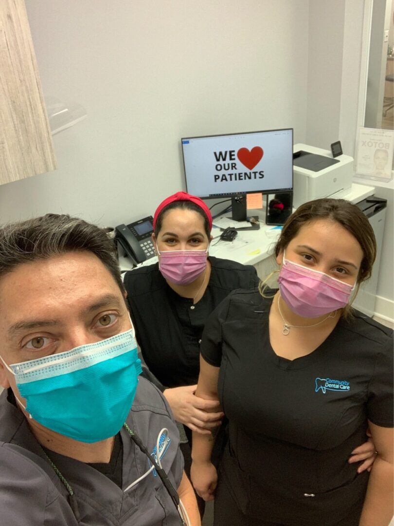 Three people wearing masks in a room.