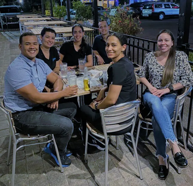 A group of people sitting at an outdoor table.