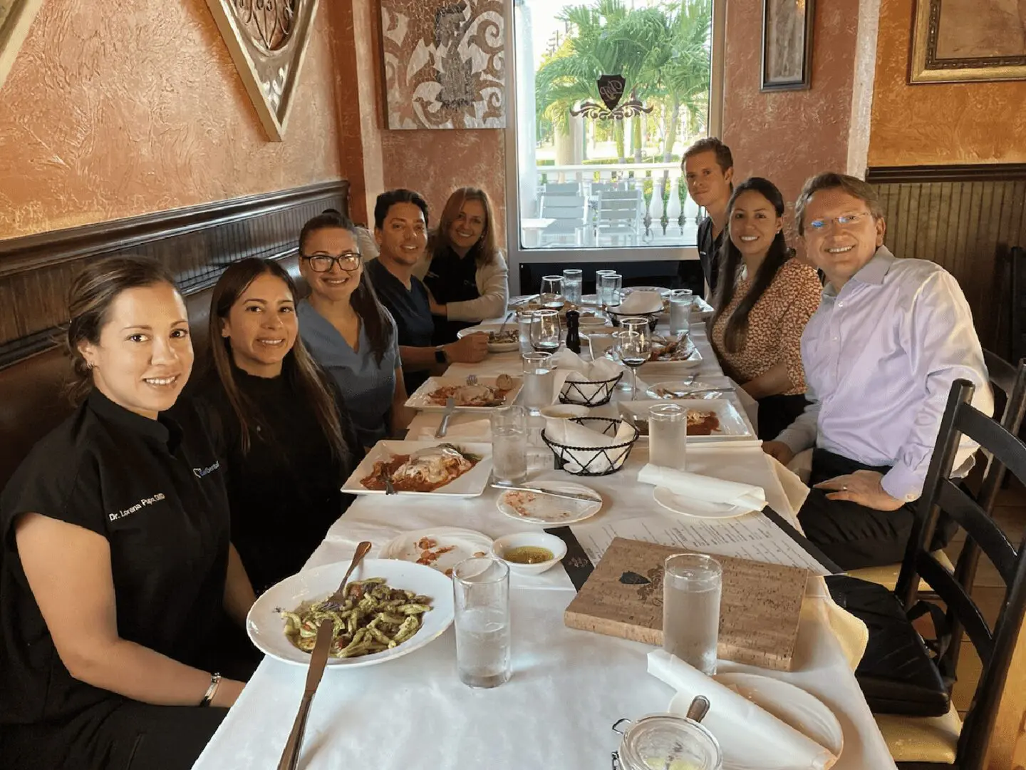 A group of people sitting at a table with plates.