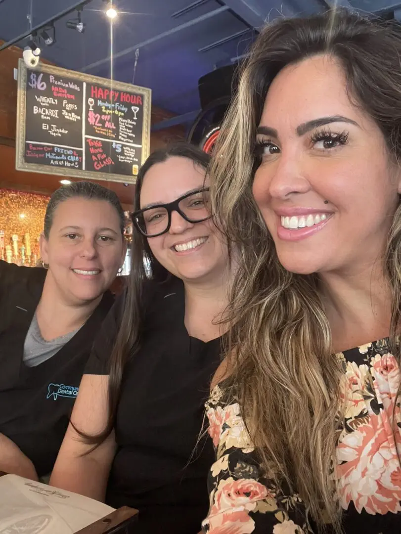 Three women are smiling for a picture.