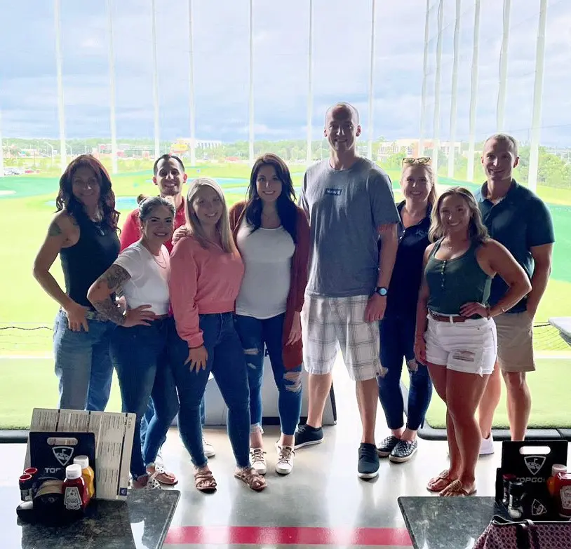 A group of people standing in front of a window.