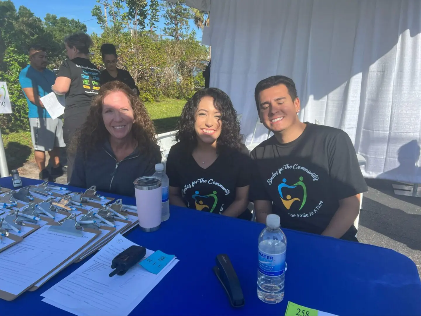 Three people sitting at a table with drinks.