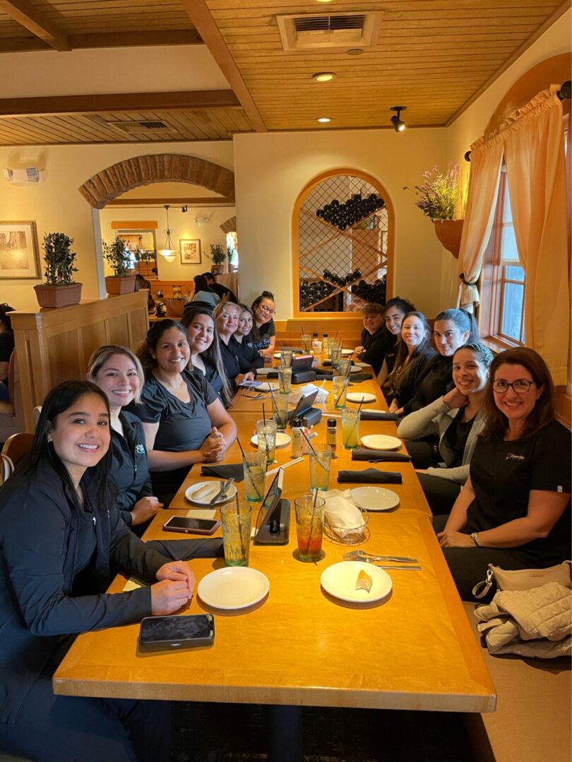 A group of people sitting at a table with plates.