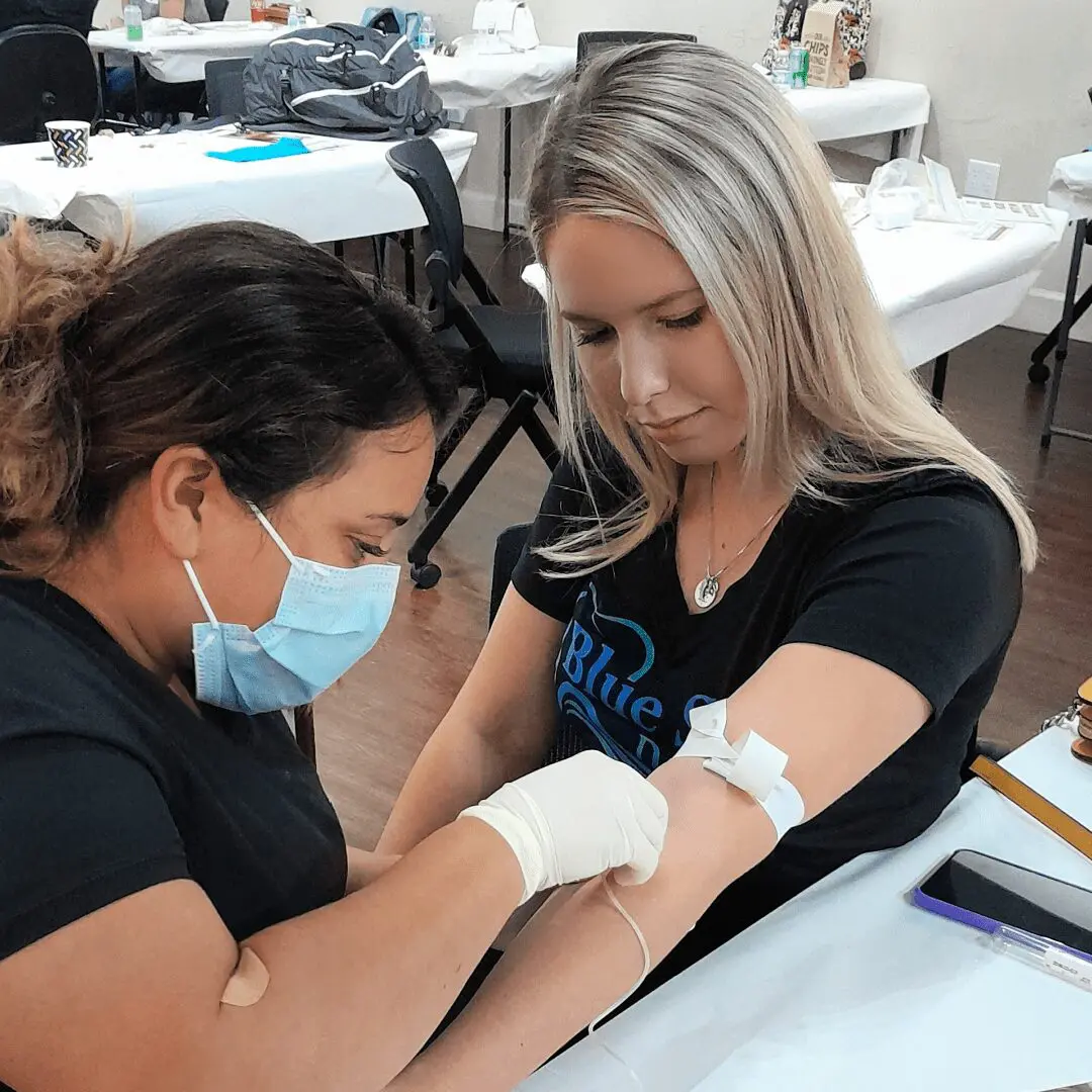 A woman getting her arm examined by another person.