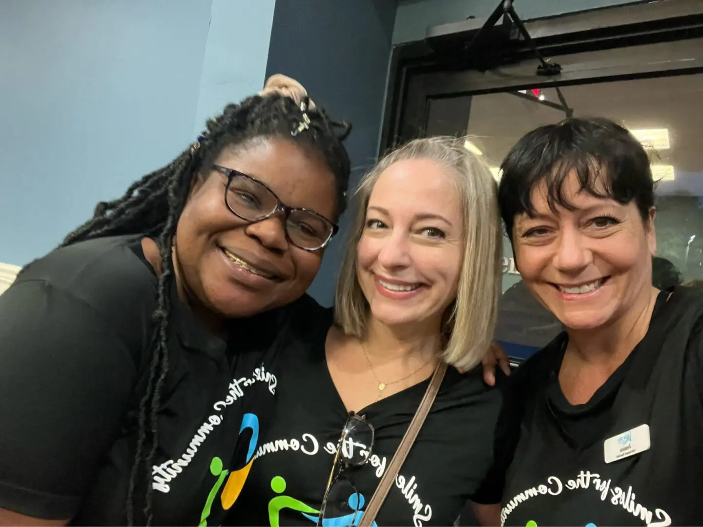 Three women are smiling for a picture.