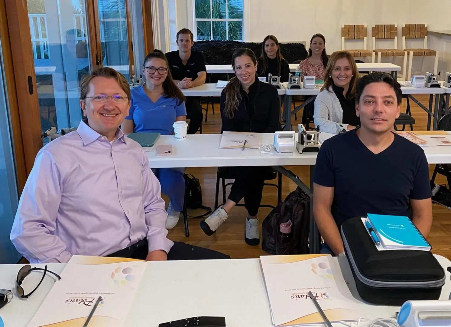 A group of people sitting at tables in front of laptops.