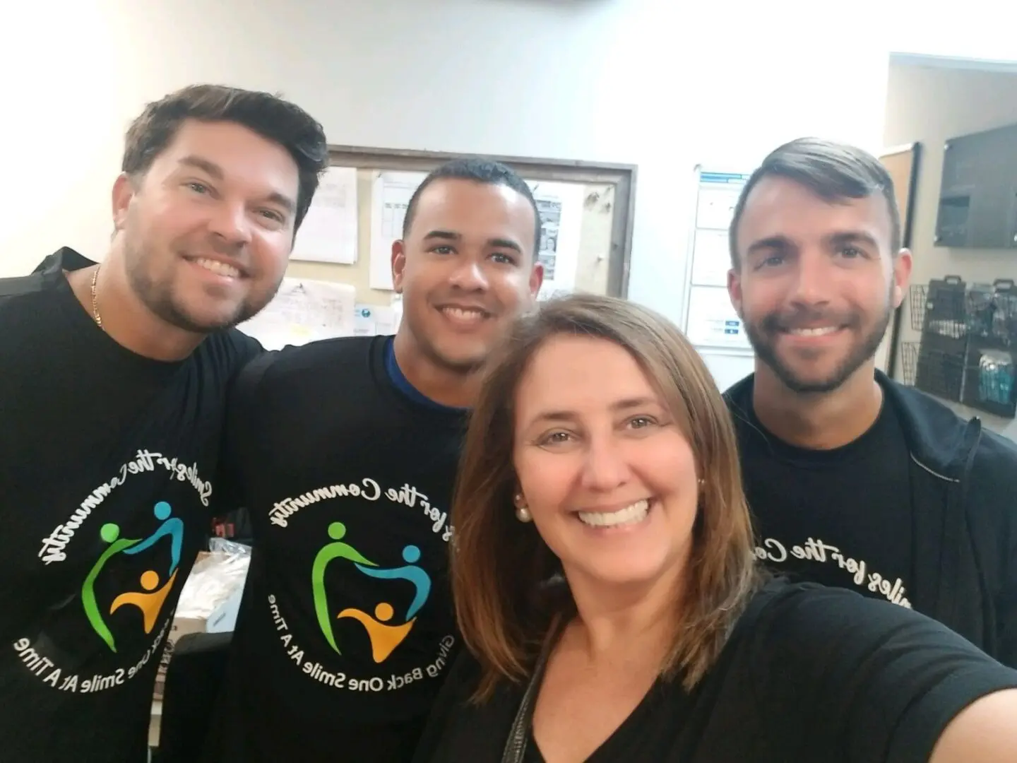 A group of people wearing black shirts and smiling.