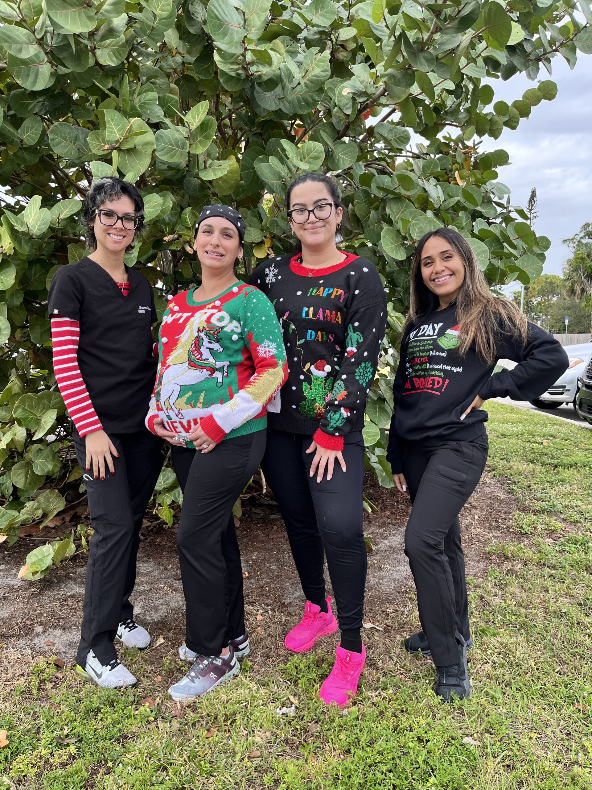 Four women in matching christmas outfits posing for a picture.