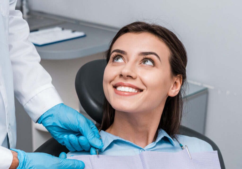 A woman getting her teeth checked by an dentist.